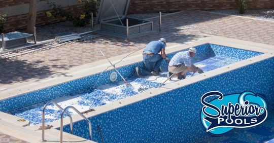 Two technicians doing outdoor pool maintenance and repairs